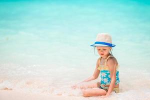 entzückendes kleines Mädchen am Strand in ihren Sommerferien foto