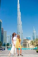 glückliche familie, die in dubai mit wolkenkratzern im hintergrund geht. foto