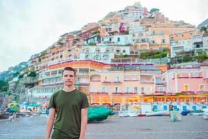 sommerferien in italien. junger Mann im Dorf Positano im Hintergrund, Amalfiküste, Italien foto