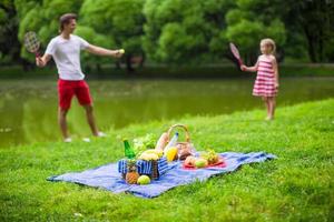 glückliche Familie, die im Park picknickt foto