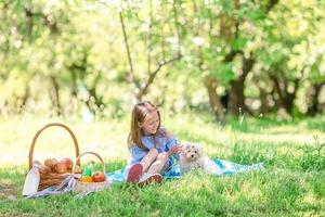 kleines Kind mit Welpen beim Picknick im Park foto