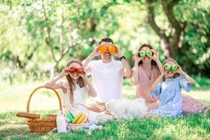 glückliche Familie auf einem Picknick im Park an einem sonnigen Tag foto