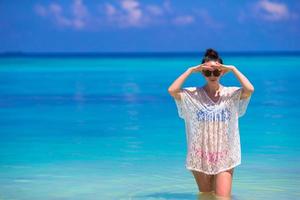 junge schöne Frau am Strand während der tropischen Ferien foto