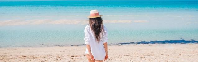 Frau, die am Strand liegt und die Sommerferien mit Blick auf das Meer genießt foto