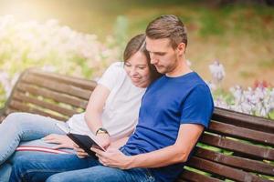 Entspannte junge Familie auf der Bank im Park foto