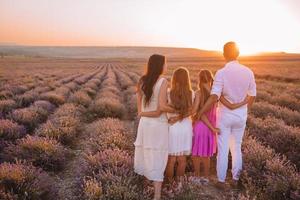 Familie im Lavendelblumenfeld bei Sonnenuntergang im weißen Kleid und im Hut foto