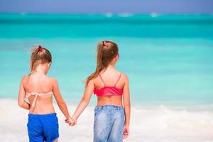 Entzückende kleine Mädchen am Strand während der Sommerferien foto