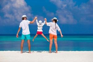 junge Familie am weißen Strand während der Sommerferien foto