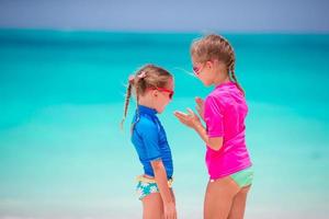 Entzückende kleine Mädchen am Strand während der Sommerferien foto