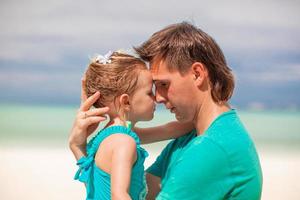 Porträt eines kleinen Mädchens und ihres jungen Vaters, die sich umarmen foto