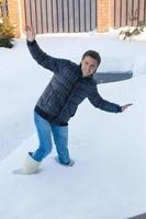 junger Mann in Winterstiefeln fiel in einen tiefen weißen Schnee foto