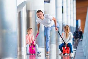 glückliche familie mit zwei kindern am flughafen viel spaß beim warten auf das einsteigen foto