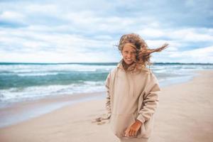 junges Mädchen am Strand im Sturm foto