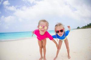 Porträt von Mädchen, die sich am tropischen Strand amüsieren foto