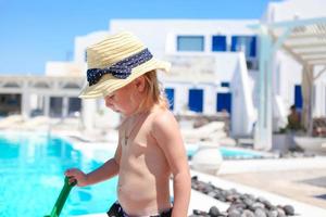 entzückendes kleines mädchen in der nähe des pools während des griechischen urlaubs auf santorini foto