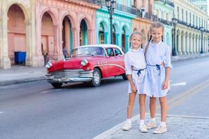 Entzückende kleine Mädchen in der beliebten Gegend in Alt-Havanna, Kuba. Porträt von zwei Kindern im Freien auf einer Straße von Havanna foto