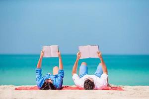 Familie mit Büchern am Meer liegend foto