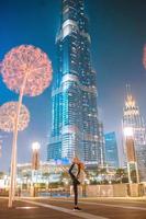 glückliches Mädchen zu Fuß in Dubai mit Wolkenkratzer im Hintergrund. foto