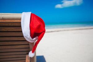 Nahaufnahme der Weihnachtsmütze auf dem Liegestuhl am tropischen karibischen Strand foto