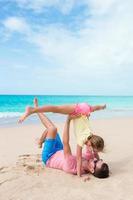 glücklicher Vater und seine kleine Tochter am tropischen Strand haben Spaß foto