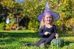 süßes kleines Mädchen in Halloween, welches Kostüm Spaß im Freien hat foto