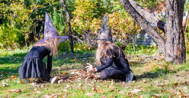 Entzückende kleine Mädchen im Hexenkostüm an Halloween haben Spaß foto