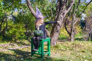 entzückendes kleines Mädchen in Halloween, welches Kostüm Spaß im Freien hat foto