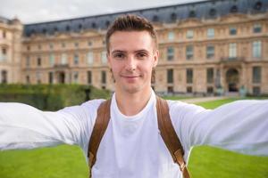 glücklicher junger mann, der ein selfie-foto in paris, frankreich macht foto