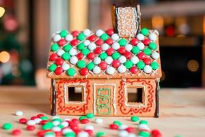 Lebkuchenfeenhaus auf einem Hintergrund von hellem Weihnachtsbaum mit Girlande foto