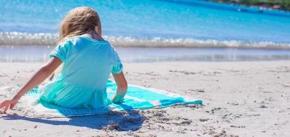 entzückendes kleines mädchen hat spaß am tropischen strand während des urlaubs foto