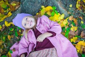 Kleines entzückendes Mädchen im Herbstpark am sonnigen Herbsttag foto