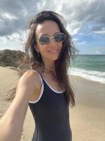 junge schöne frau, die selfie am strand macht foto