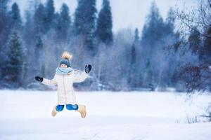 entzückendes kleines Mädchen am gefrorenen Wintertag im Freien foto