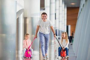 glückliche familie mit zwei kindern am flughafen viel spaß beim warten auf das einsteigen foto