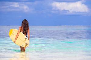 junge surferfrau, die während des strandurlaubs surft foto