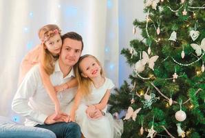 glücklicher dada mit kindern nahe dem weihnachtsbaum am weihnachtsabend foto