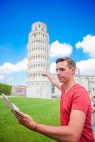 kleiner Junge mit touristischer Karte auf Reisen nach Pisa. tourist, der den schiefen turm von pisa besucht. foto