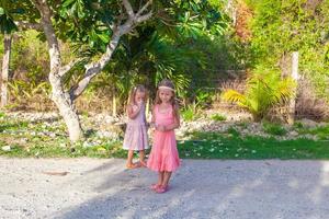 zwei kleine Mädchen auf Fußweg in einem tropischen Land foto
