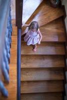 wunderbares kleines Mädchen auf der Treppe in einem großen Haus