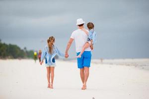 junge Familie am weißen Strand während der Sommerferien foto