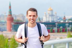 junger Mann Wandern lächelnd glücklich Porträt. männlicher wanderer, der in die stadt geht foto