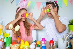 Vater und seine kleine Tochter malen Eier. glückliche familie, die sich auf ostern vorbereitet. foto