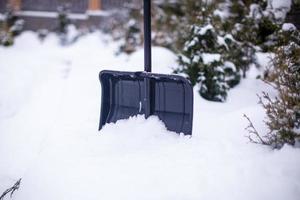 Metallschaufel in einer großen hohen Schneeverwehung am Wintertag foto