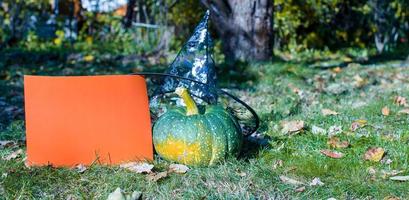 Blick auf Halloween-Kürbisse, Hexenhut und Rechen im Freien foto