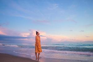 Frau, die am Strand liegt und die Sommerferien mit Blick auf das Meer genießt foto