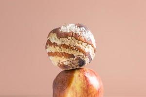 Apfel mit Schimmel und frischer Apfel im Hintergrund - Konzept für Schimmelwachstum und Lebensmittelverderb foto