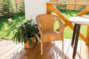 gemütliche Holzterrasse des Landhauses oder Landhauses mit Blick in den Garten - Tisch und Stuhl für entspannte Abende foto