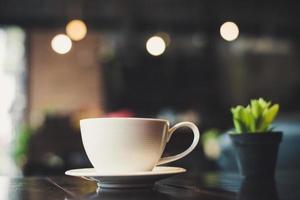 Kaffeetasse mit Kaktus auf Holztisch foto