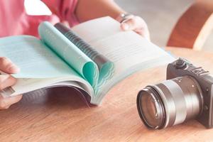 Frau liest ein Buch mit einer Kamera foto