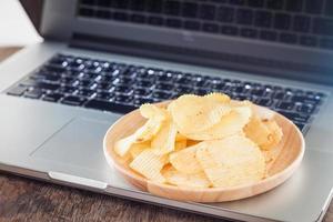 Teller mit Chips auf einem Laptop foto